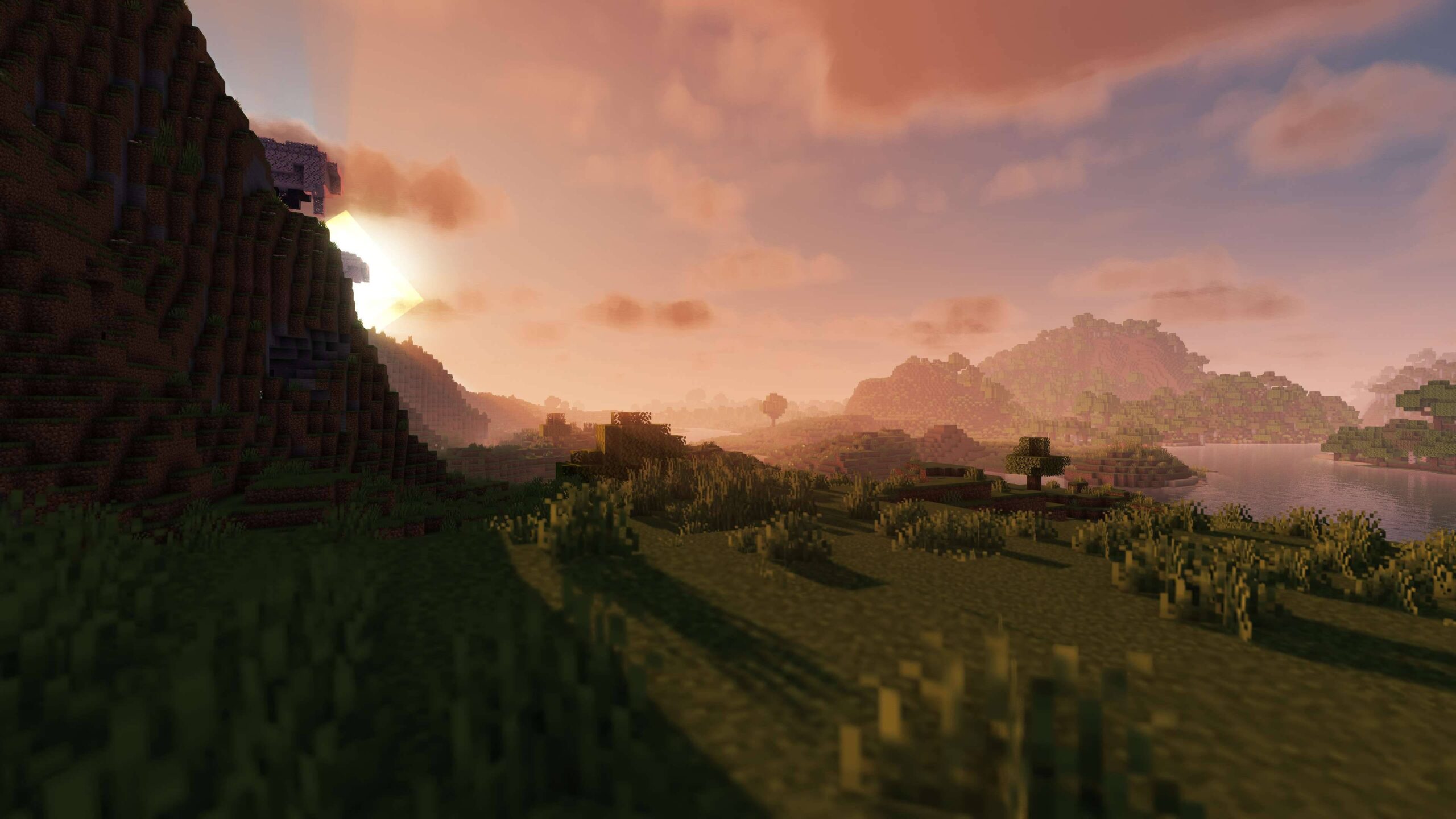 Coucher de soleil dans Minecraft avec E-LITE shaders, ciel orangé et lumière chaude sur le paysage