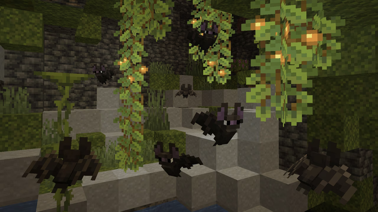 Plusieurs chauves-souris dans une grotte sombre de Minecraft.