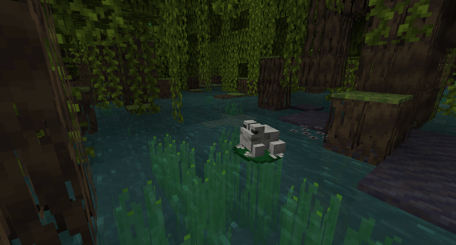 Grenouille chaude dans un marais à mangroves de Minecraft, posée près de la boue et des racines.