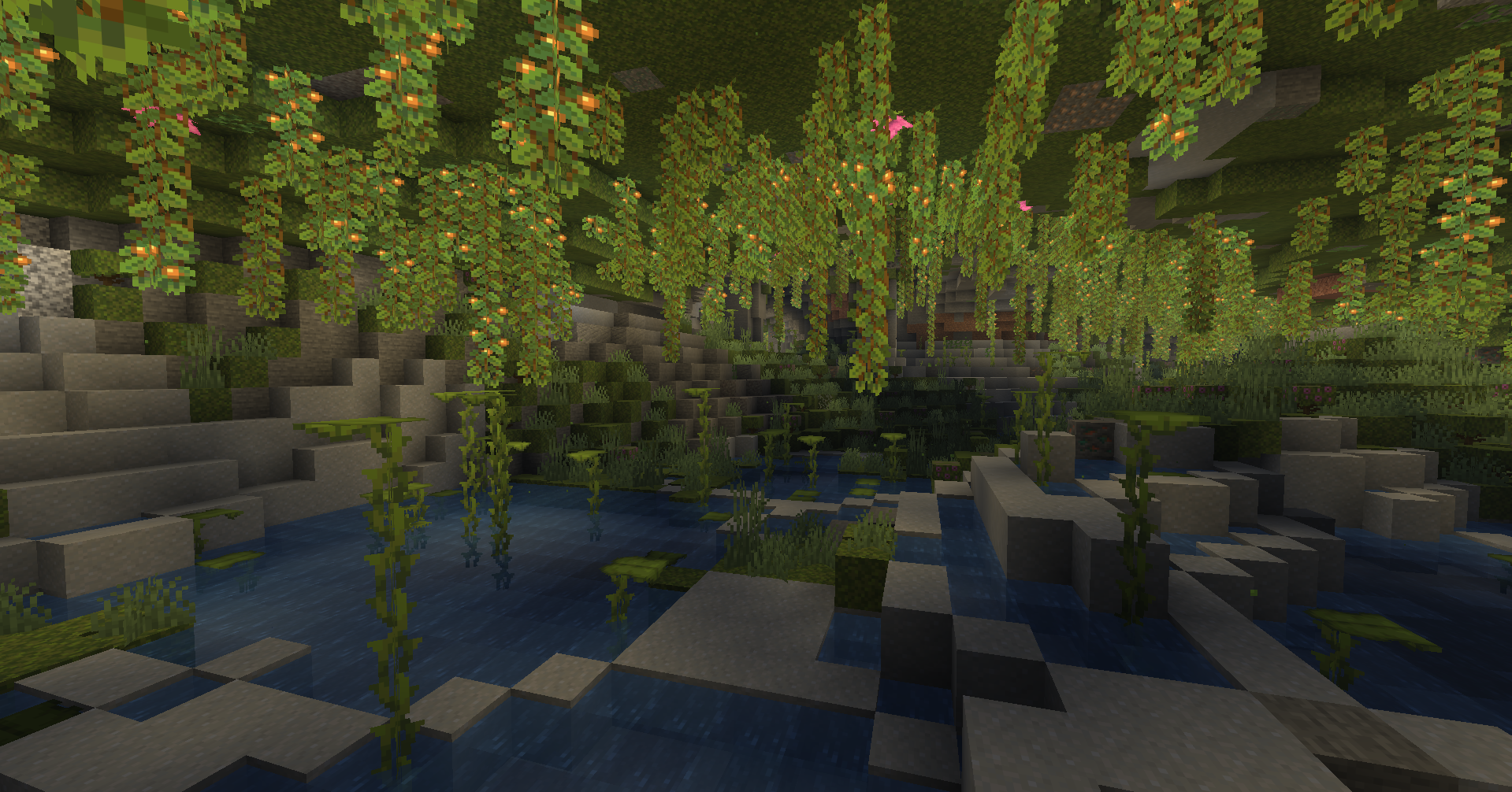 Caverne luxuriante de Minecraft recouverte de mousse, de lianes et de baies lumineuses.