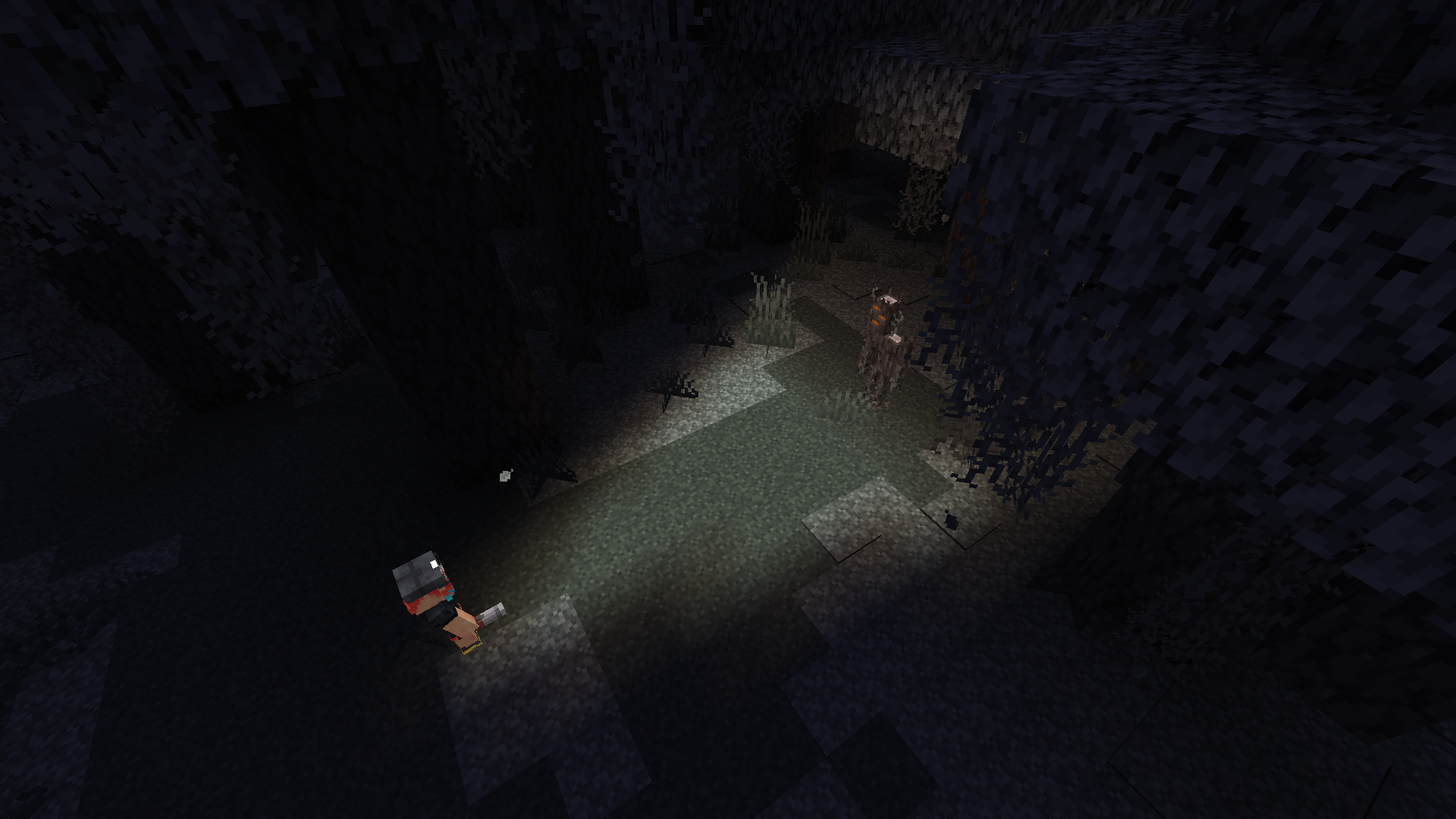 Lampe torche du mod Illuminated éclairant une créature dans une forêt sombre de Minecraft